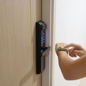 Hand using smartwatch for open digital door lock at home or apartment. NFC Technology, Fingerprint scan, keycard, PIN number, smartphone, electrical and contactless lifestyle concepts